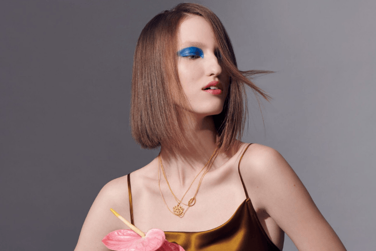 Auvere 22k and 24k gold jewelry: rings, bracelets and necklaces on a model
