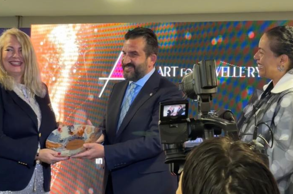 Esther receiving gift on stage with the president of the Turkish Jewelry Association and RJC president Melanie Grant